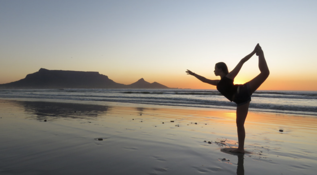 woman doing yoga on the beach